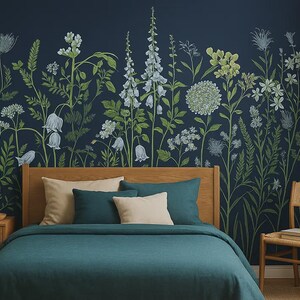Könnte beinhalten: Ein Schlafzimmer mit einer türkisfarbenen Tagesdecke, einem hölzernen Kopfteil und einem Nachttisch mit einer Lampe. Die Wand ist mit einem Blumengemälde in Grün und Weiß auf dunkelblauem Hintergrund verziert. Ein Korbstuhl ist ebenfalls vorhanden.