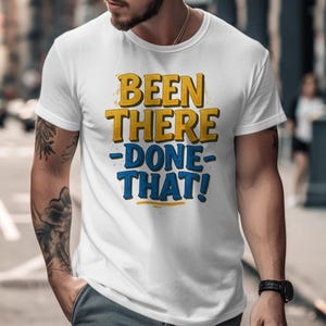 May include: White t-shirt with a blue and yellow graphic that says "Been There -Done- That!"