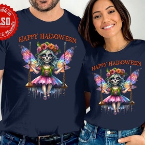 May include: Navy blue t-shirts with a Halloween-themed graphic. The design features a fairy with a sugar skull face, colorful wings, and a floral crown, swinging on a wooden swing. The text "HAPPY HALLOWEEN" is printed above the fairy.
