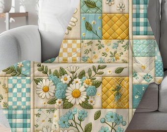 Könnte beinhalten: Eine Patchwork-Decke mit einem Blumendesign aus Gänseblümchen und blauen Blumen. Die Decke hat gelbe, blaue und weiße Quadrate mit Mustern wie Vichy-Karo und Blumendrucken. Die Decke ist über ein graues Sofa drapiert.