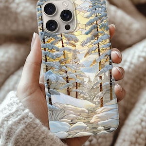 May include: A phone case with a winter forest design, showing snow-laden trees and a bright yellow and orange sky. The artwork has a stained glass effect, using a light blue and white colour scheme.