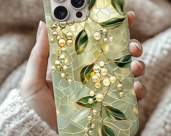 May include: A decorative phone case featuring a stained-glass design with green leaves, golden berries, and a network of gold lines. The case has a light green and yellow background and is designed for a smartphone.