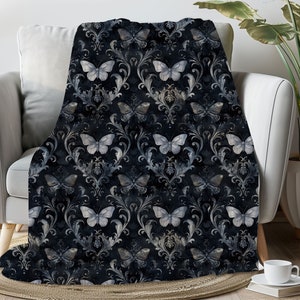 May include: A black and white throw blanket with a damask pattern and white butterflies. The blanket is soft and cozy, perfect for adding a touch of elegance to any room.