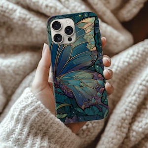 May include: A smartphone case featuring a detailed butterfly design in shades of blue, teal, and purple. The butterfly wings are the focal point, with intricate patterns and a stained-glass effect. The case has a glossy finish.