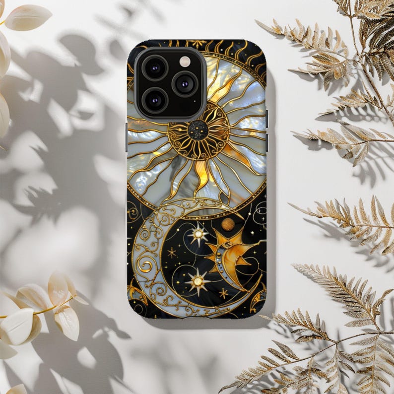 May include: A black smartphone case featuring a celestial design with a sun, moon, and stars. The sun is gold and white, while the moon is gold and light blue. The case has a glossy finish and a decorative pattern.