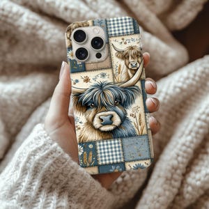 Puede incluir: Funda de teléfono con diseño de patchwork e ilustraciones de vacas de las Tierras Altas. La funda combina cuadrados azules, beige y blancos con motivos florales y de cuadros. La imagen principal es un primer plano de la cara de una vaca de las Tierras Altas.