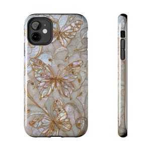 Puede incluir: Una funda para smartphone con un diseño de incrustaciones de nácar iridiscente, motivos de mariposas en tono dorado y patrones de filigrana. La funda presenta un acabado brillante y multicolor, con una vista lateral del borde fino.