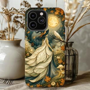 May include: A smartphone case featuring a graphic illustration of a figure in a flowing cream-colored dress and a dark hat standing in a forest at night. The scene includes a large yellow moon, a white raven on a branch, orange autumn leaves, and mushrooms.