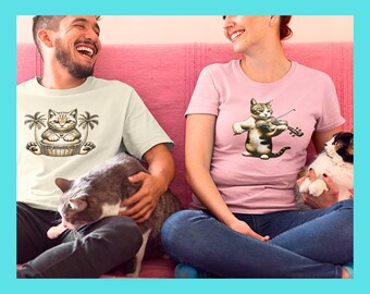 May include: Two people wearing t-shirts with cat illustrations. The man is wearing a white t-shirt with a cat playing the drums. The woman is wearing a pink t-shirt with a cat playing the violin.