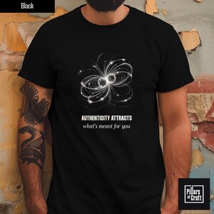 Peut inclure: T-shirt noir avec un motif floral abstrait blanc et le texte "AUTHENTICITY ATTRACTS what's meant for you". Le motif est symétrique. Le t-shirt est de la marque Pillars of Craft.