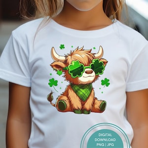 May include: A white t-shirt with a cartoon image of a brown Highland cow wearing green shamrock sunglasses and a green bandana. The cow is surrounded by green shamrocks and stars.