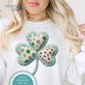 Può includere: Felpa bianca con un grande trifoglio applicato. Il trifoglio ha tre foglie a forma di cuore in verde chiaro, con dettagli floreali e stampa leopardata. Il testo "DIGITAL DOWNLOAD PNG | JPG" è in basso.