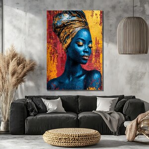 May include: A striking portrait of a woman with blue skin and gold accents. She wears a gold head wrap and has gold eyeshadow and lipstick. The background is a textured mix of red and gold, creating a vibrant and artistic wall art piece.