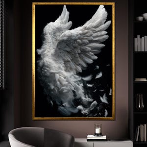 May include: A framed art print featuring a large, detailed white angel wing against a black background. The wing is composed of layered feathers, with some feathers appearing to detach and float away. The frame is gold.