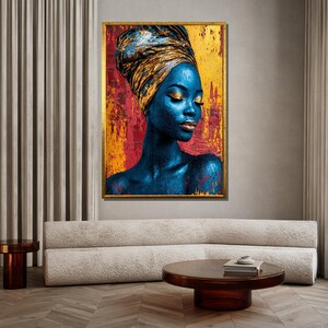 May include: A framed portrait of a woman with blue skin and gold accents. She wears a gold head wrap and has gold eyeshadow and lipstick. The background is a mix of red, yellow, and gold, with a gold frame.