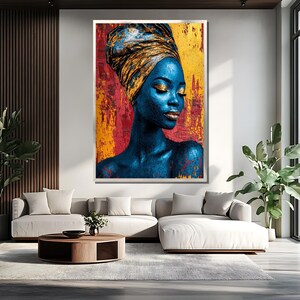 May include: A large framed art print featuring a portrait of a woman with blue skin and a gold head wrap. The background is a textured mix of red, yellow, and gold. The woman has closed eyes and gold makeup.