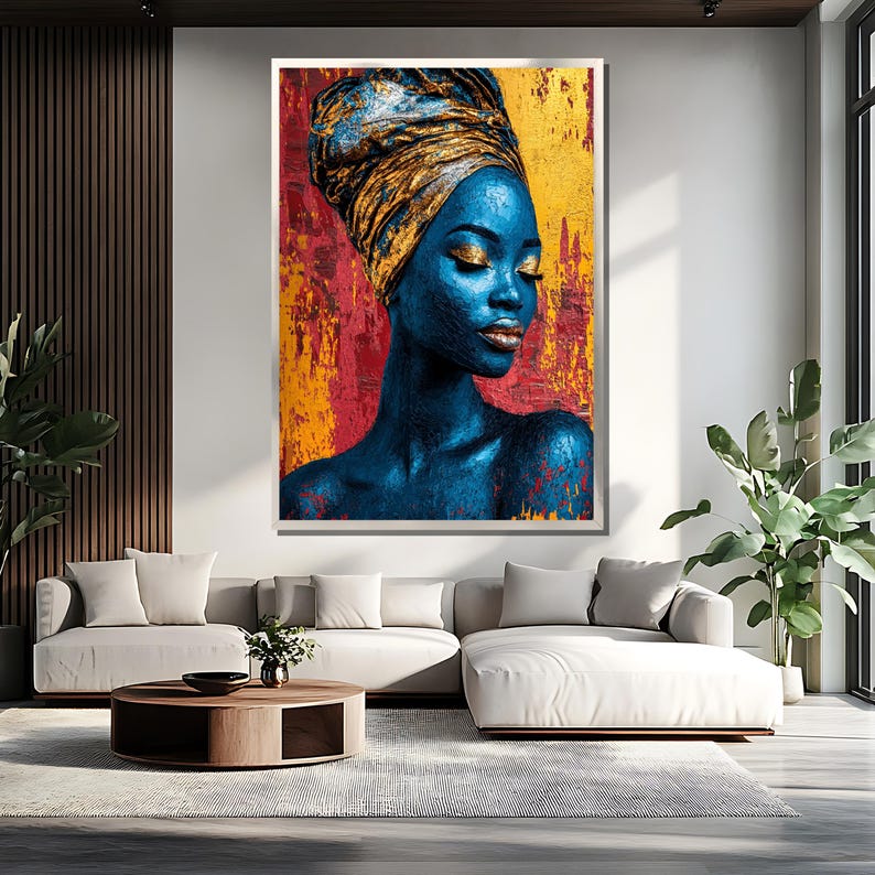 May include: A large framed art print featuring a portrait of a woman with blue skin and a gold head wrap. The background is a textured mix of red, yellow, and gold. The woman has closed eyes and gold makeup.