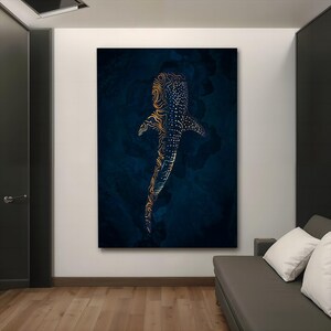 K&ouml;nnte beinhalten: Ein digitaler Kunstdruck eines Walhais mit goldenen und schwarzen Mustern, der in einem dunkelblauen Ozean schwimmt. Der Druck ist gerahmt und h&auml;ngt an einer wei&szlig;en Wand in einem Raum mit einem grauen Sofa.