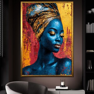 May include: A framed portrait of a woman with blue skin and gold makeup, wearing a gold head wrap. The background features a textured mix of red and gold paint. The artwork is displayed in a room with a dark gray wall.