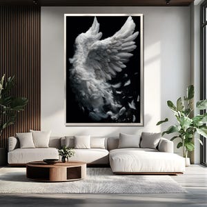 May include: Large framed artwork featuring a detailed depiction of a white angel wing against a black background. The wing is rendered with soft, feathery textures, with some feathers drifting away. The artwork is displayed in a modern living room setting.