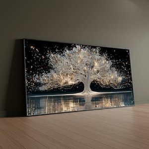 May include: A rectangular wall art print featuring a large, white, glowing tree centered against a solid black background. The tree branches are filled with bright, golden light particles that appear to be floating or falling, with a clear reflection of the tree and lights visible on a smooth, dark surface below.