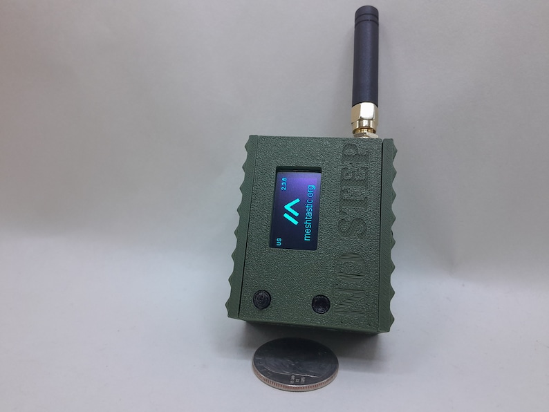 May include: A green, rectangular device with a small screen displaying "mesh.asic.org" and a signal strength indicator. The device has a black antenna and the text "Mini-STRD" printed on the side.