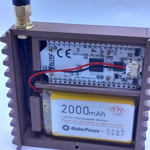 May include: A brown plastic case containing a circuit board and a 2000mAh lithium rechargeable battery. The battery label reads "MakerFocus" and features a gear icon. The battery is 3.7V and 7.4Wh.