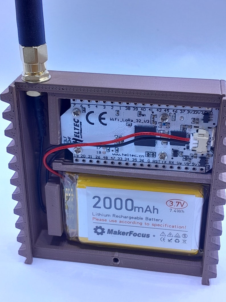 May include: A brown plastic case containing a circuit board and a 2000mAh lithium rechargeable battery. The battery label reads "MakerFocus" and features a gear icon. The battery is 3.7V and 7.4Wh.