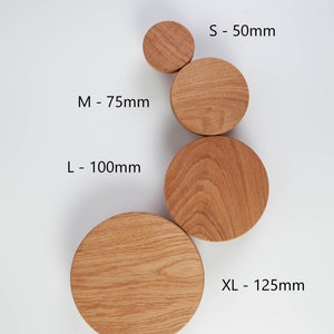 May include: Four wooden wall hooks in different sizes: small (50mm), medium (75mm), large (100mm), and extra large (125mm). The hooks are natural wood color.