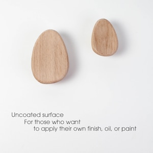Pu&ograve; includere: Due ganci in legno non rivestiti a forma di uovo. I ganci sono grezzi e pronti per essere tinti, verniciati o oliati.