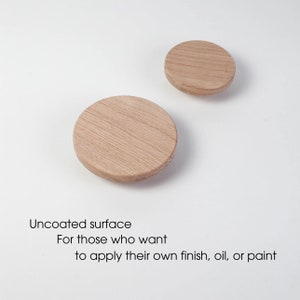 May include: Two uncoated wooden circles, one larger than the other, on a white background. The text "Uncoated surface" is below the circles, followed by "For those who want to apply their own finish, oil, or paint."