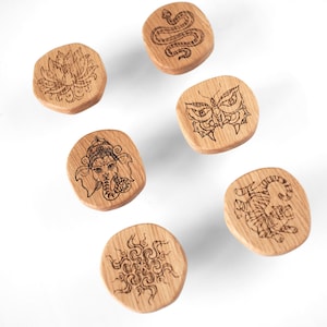 May include: A selection of wooden cabinet knobs with engraved designs, including a snake, owl, lotus flower, tiger, sunburst, and an elephant-headed deity. Made from natural German oak. The image text reads "Price shown is for one knob."