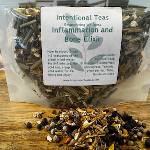 Op de afbeelding: Een doorzichtige plastic zak gevuld met een mengsel van gedroogde kruiden en bloemen, met het label "Intentional Teas Inflammation and Bone Elixir". Het label bevat instructies voor het trekken van de thee en somt de ingrediënten op:  Bardana-wortel, Echinacea, Vlierbessen, Citroengras, Kurkuma, Vitex-bessen, Tulsi en Paardenbloemwortel.