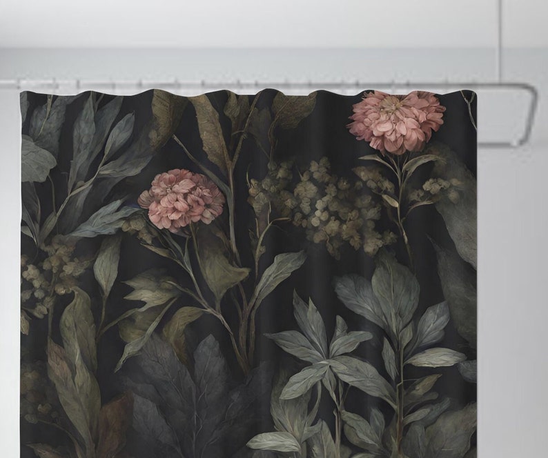 May include: Shower curtain with a dark background and a botanical print. The design features large leaves and flowers in shades of green, gray, and dusty rose. The curtain is hanging from a white shower rod.