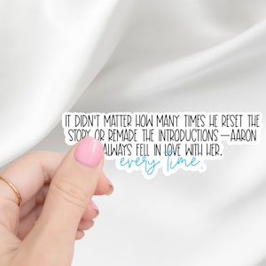 May include: A white sticker with black text that reads, "IT DIDN'T MATTER HOW MANY TIMES HE RESET THE STORY OR REMADE THE INTRODUCTIONS - AARON ALWAYS FELL IN LOVE WITH HER. every time." The words "every time" are in blue.