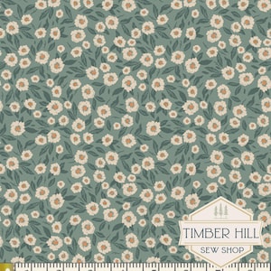 May include: A floral fabric with a repeating pattern of white flowers with orange centers and green leaves on a teal background. The fabric is measured with a ruler that shows 1 inch increments.
