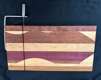 Tabla de quesos de madera variada con diseño ondulado.