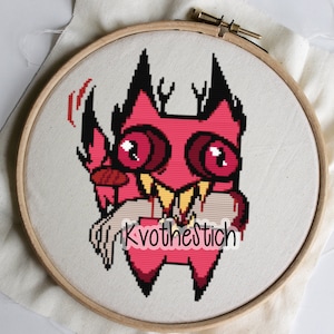 Puede incluir: Patrón de punto de cruz de un personaje de dibujos animados rosa con cuernos negros y grandes ojos rojos. El personaje sonríe con dientes afilados y lleva un collar amarillo. El texto "Kvothestitch" es visible en la parte inferior central de la imagen.