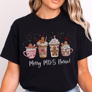May include: Black t-shirt with a Christmas-themed design featuring four mugs with gingerbread men and the text "Merry MDS Nurse!"