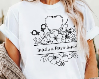 May include: White t-shirt with a black and white graphic design of a stethoscope, syringe, scissors, and flowers. The text "Infection Preventionist" is printed on the shirt.