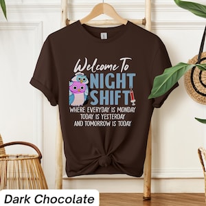 May include: A dark chocolate brown t-shirt with a graphic of two owls wearing nurse hats and the text "Welcome to Night Shift" with the tagline "Where everyday is Monday, today is yesterday and tomorrow is today".