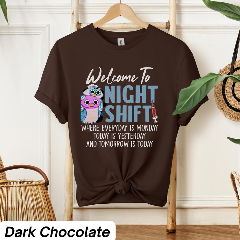 May include: A dark chocolate brown t-shirt with a graphic of two owls wearing nurse hats and the text "Welcome to Night Shift" with the tagline "Where everyday is Monday, today is yesterday and tomorrow is today".