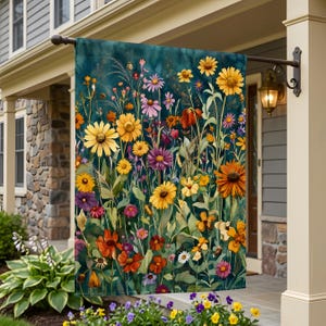Könnte beinhalten: Eine dekorative Gartenflagge mit einem Aquarellgemälde einer Wildblumenwiese. Die Flagge zeigt eine Vielzahl farbenfroher Blumen in Gelb-, Orange-, Lila- und Rosatönen vor einem dunkelblauen Hintergrund. Die Flagge hängt an einer Veranda.