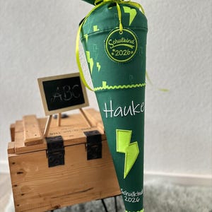 Könnte beinhalten: Ein Set aus drei Keramikbechern mit gesprenkelter, matter Oberfläche. Die Becher sind in den Farbtönen Creme, Hellgrau und Dunkelgrau gehalten. Jeder Becher hat ein schlichtes, minimalistisches Design, perfekt für Kaffee oder Tee.