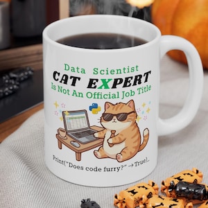 May include: White ceramic mug with a handle, featuring a cartoon cat wearing sunglasses and a tie, working on a laptop. Text reads "Data Scientist CAT EXPERT Is Not An Official Job Title" and "Print("Does code furry?" -> True)".