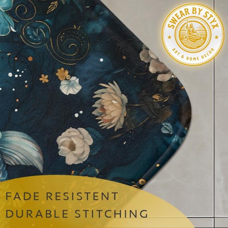 May include: A dark blue bath mat with a floral pattern featuring white and gold flowers. The mat has a rounded edge and the text "SWEAR BY STYX ART & HOME DECOR" is printed in a yellow circle in the top right corner. The text "FADE RESISTANT DURABLE STITCHING" is printed in yellow at the bottom of the image.
