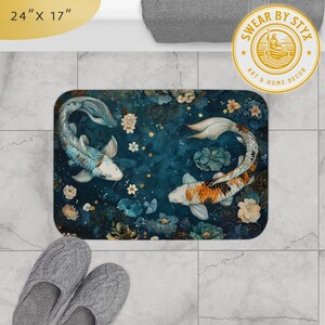 May include: A blue and gold bath mat with a floral design and two koi fish swimming in opposite directions. The mat is 24 inches by 17 inches. "SWEAR BY STYX ART & HOME DECOR" is printed in a gold circle on the mat.