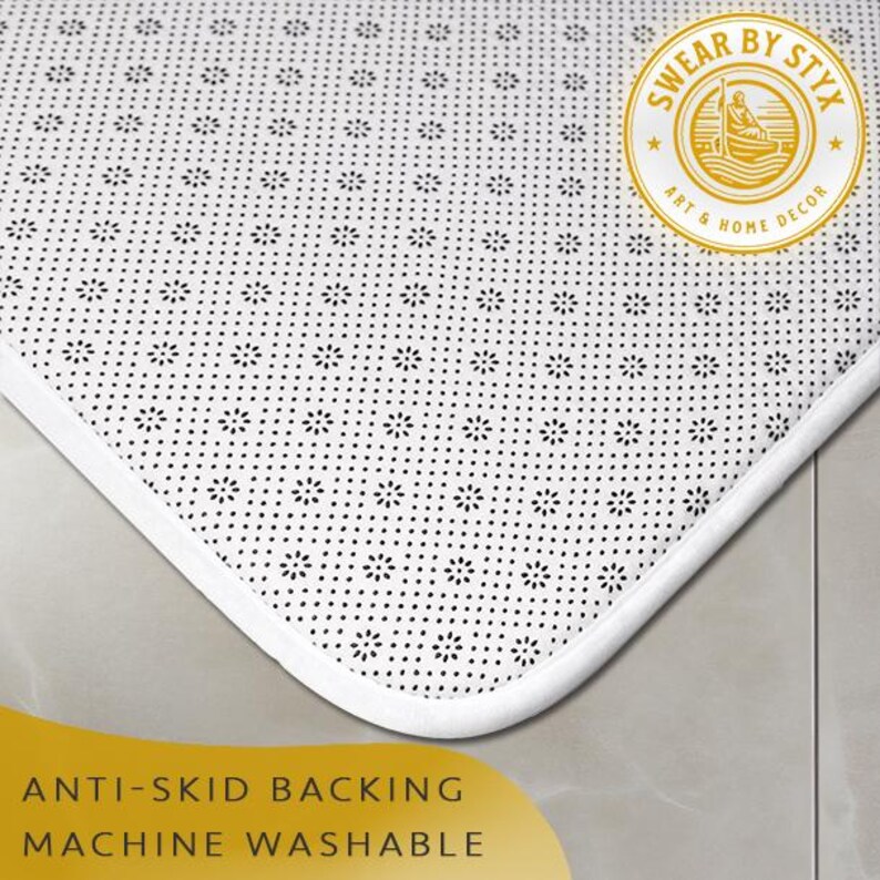May include: White bath mat with a black non-slip backing. The mat has a white border and the text "Swear by Styx Art & Home Decor" is printed on the mat.