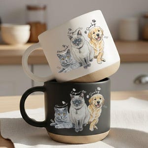 May include: Two ceramic mugs, one cream and one black, stacked on top of each other. Each mug features illustrations of cats and a golden retriever, with the names "Henry", "Lupin", and "Sooky" above the animals. The mugs have a tan base.
