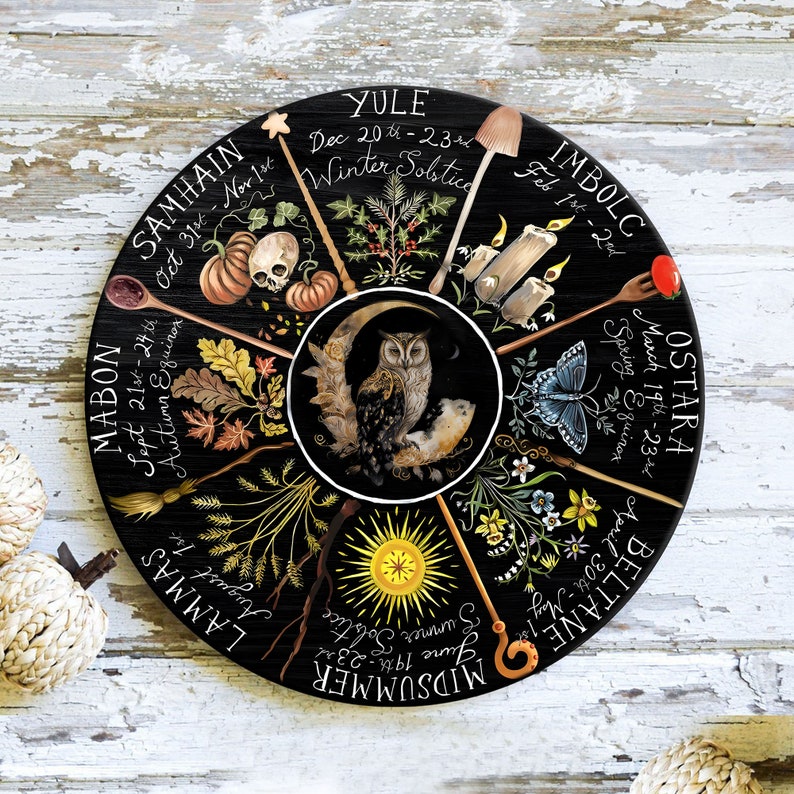 Pode incluir: Uma roda circular preta com oito raios, cada um representando uma &eacute;poca diferente do ano na Roda do Ano. Os raios s&atilde;o etiquetados com os nomes dos oito sabbats: Yule, Imbolc, Ostara, Beltane, Midsummer, Lammas, Mabon e Samhain. Cada raio tamb&eacute;m inclui um intervalo de datas e um s&iacute;mbolo que representa a esta&ccedil;&atilde;o.
